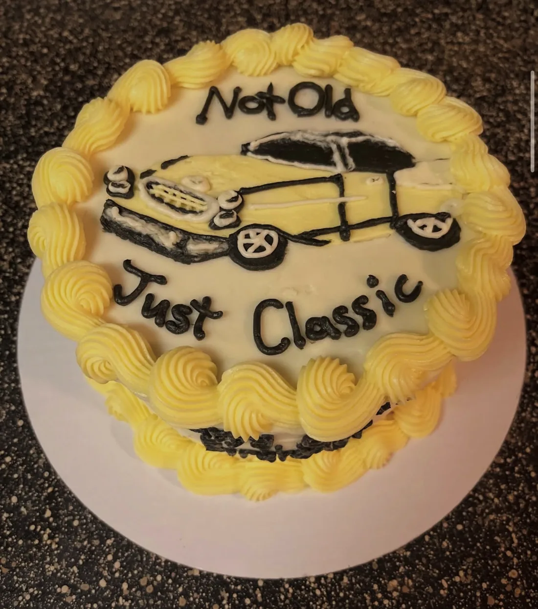 A cake hand-piped with a classic car and the words Not Old Just Classic