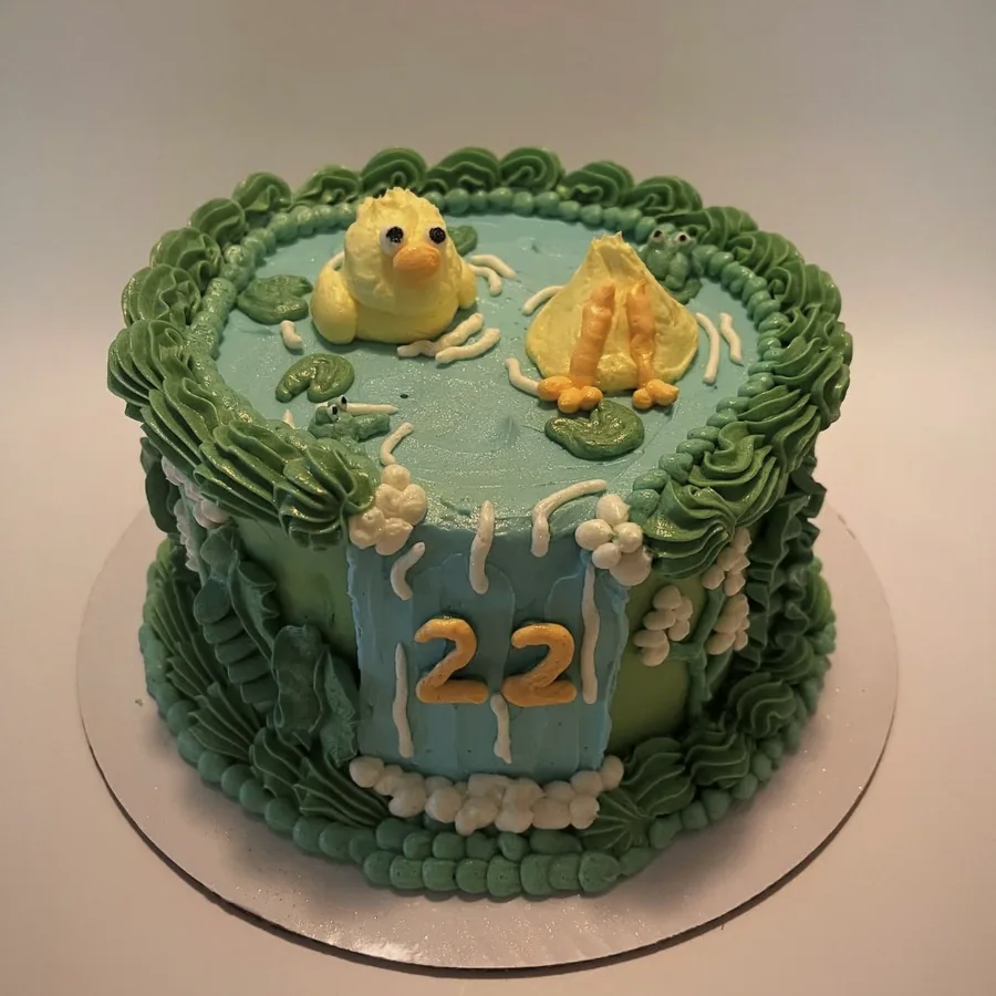 A green and blue pond cake with piped frogs and lily pads for a twenty-second birthday