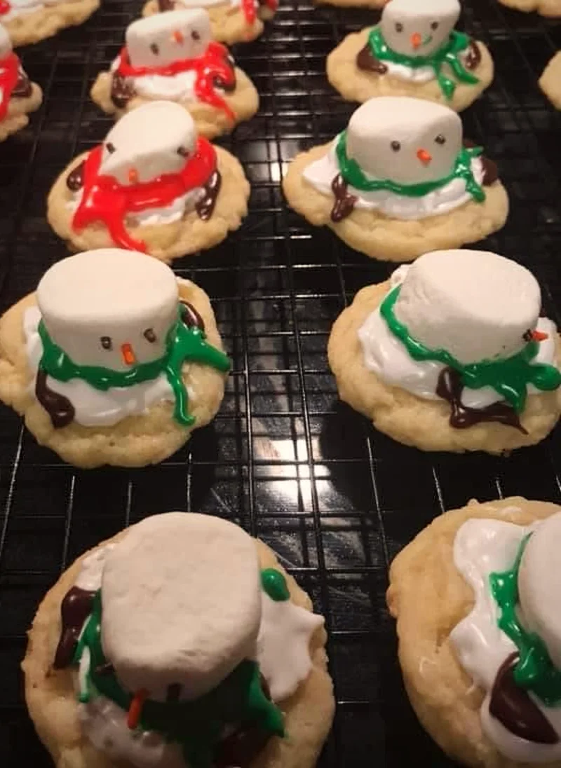 Rows of Ava's iced snowman sugar cookies cooling on a wire rack