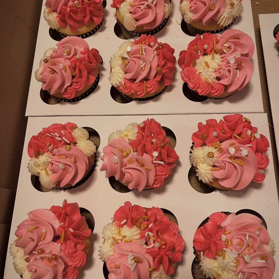 A dozen cupcakes piped with pink and cream buttercream roses