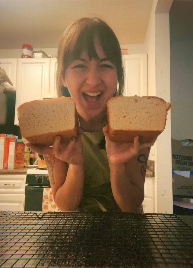 Ava today, laughing, holding up two halves of a loaf she has just cut open